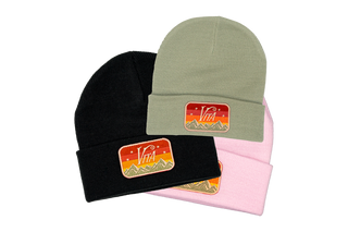 Stack of three beanies in black, mint, and orchid with Del Sol Vitalogy patches