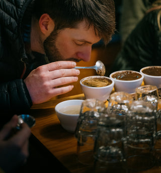 Person cupping coffee at one of Caffe Vita's public cuppings at KEXP.