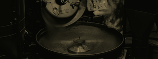 Black and white image of Probat roaster in the process of roasting beans.